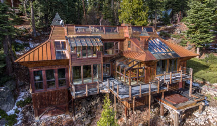 Arial view of large wood cabin with glass sunroofs